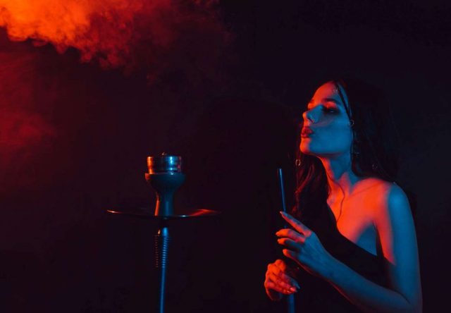 young girl enjoys smoking a hookah