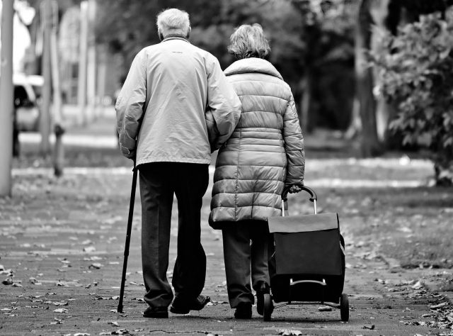 elderly-couple-walking-park-trees