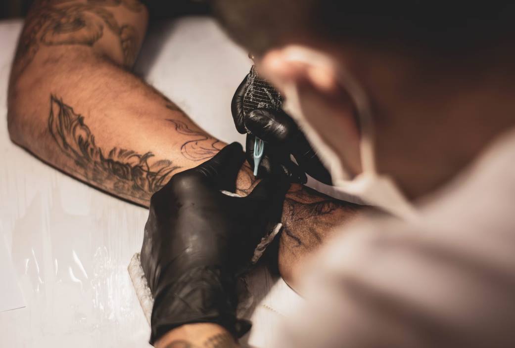 person making tattoo
